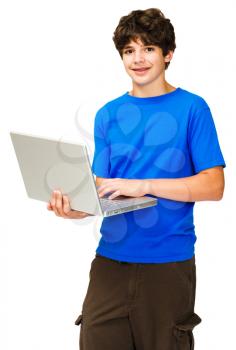 Smiling boy using a laptop isolated over white