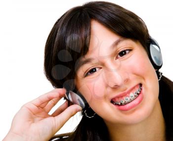 Teenager wearing headphones and listening to music isolated over white
