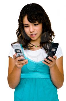 Close-up of a teenage girl text messaging on mobile phones isolated over white