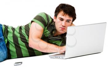 Lying man using a laptop and posing isolated over white