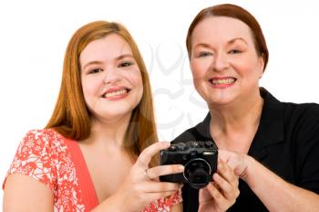 Portrait of two women holding a camera isolated over white
