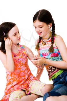 Happy girls listening to MP3 player isolated over white
