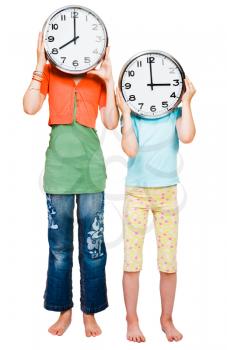 Sisters holding clocks isolated over white