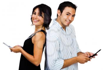 Couple text messaging on mobile phones and smiling isolated over white
