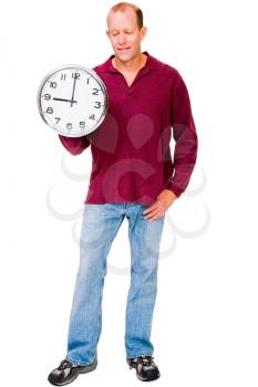 Man showing a clock and smirking isolated over white