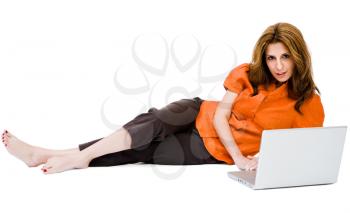 Smiling woman using a laptop and posing isolated over white