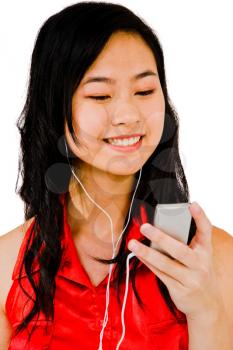 Smiling woman listening to music on a MP3 player isolated over white