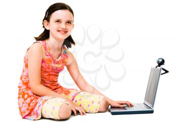 Close-up of a girl using a laptop and posing isolated over white