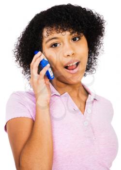 Portrait of a teenage girl talking on a mobile phone isolated over white
