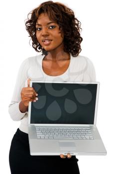 Young woman showing a laptop and posing isolated over white