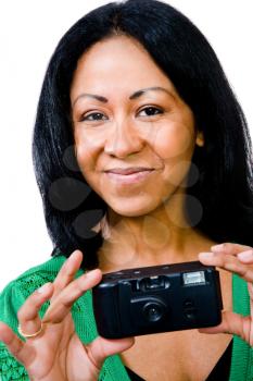 Woman photographing with a camera and smiling isolated over white