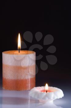 Close-up of two colorful candles burning