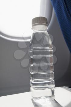 Water bottle on seat tray in an airplane, New Delhi, India