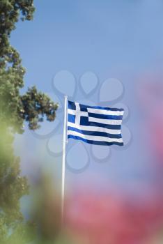 Greek flag fluttering against the blue sky, Athens, Greece