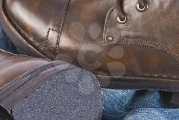 Close-up of a pair of leather boot with jeans