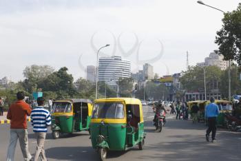 Auto rickshaws and people moving on the road, New Delhi, India