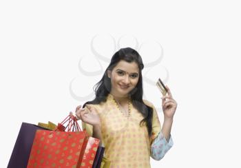 Young woman holding shopping bags and showing a credit card