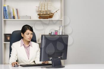 Businesswoman working on a desktop PC in an office