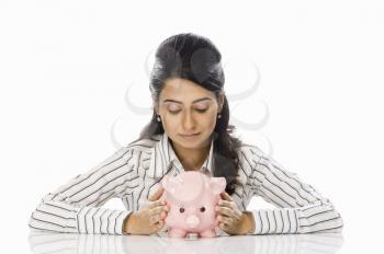 Close-up of a businesswoman holding a piggy bank