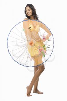 Portrait of a female fashion model holding a parasol against white background