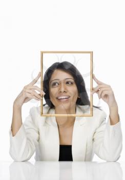 Businesswoman looking through a picture frame