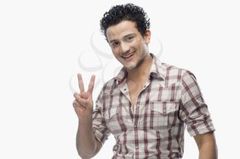 Portrait of a man showing victory sign