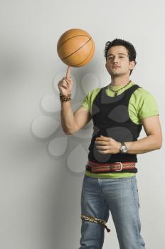 Portrait of a man balancing a basketball on fingertip