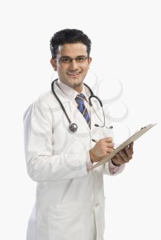 Portrait of a doctor writing on a clipboard