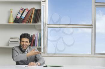 Businessman gesturing and smiling in an office
