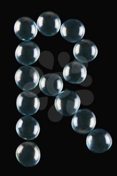 Close-up of marble balls arranged in the shape of letter R