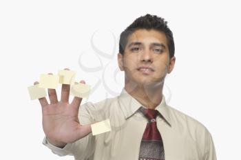 Portrait of a businessman with adhesive notes on his fingers