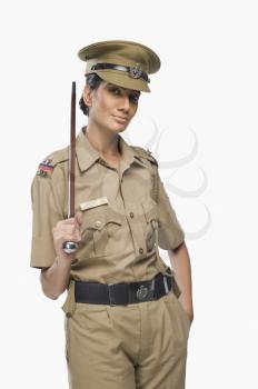 Portrait of a female police officer holding a stick