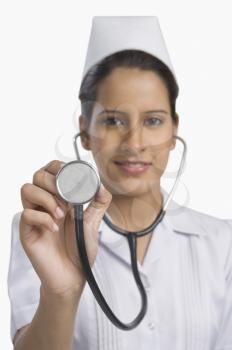 Female nurse holding a stethoscope and smiling