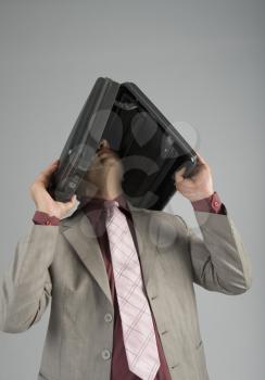 Businessman holding a briefcase over his head
