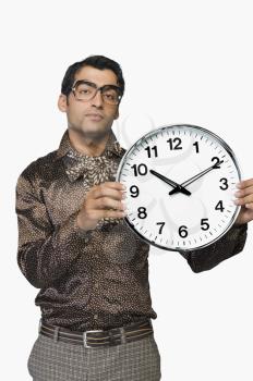 Portrait of a businessman showing a clock