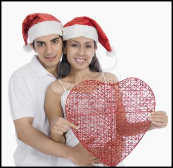 Portrait of a couple wearing Santa hats and romancing