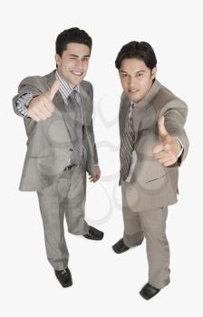 Two businessmen showing thumbs up sign
