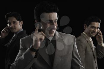 Three businessmen talking on mobile phones