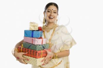Portrait of a woman in traditional saree holding gifts and smiling