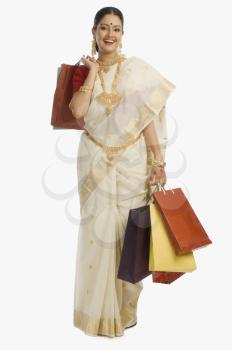 South Indian woman holding shopping bags and smiling