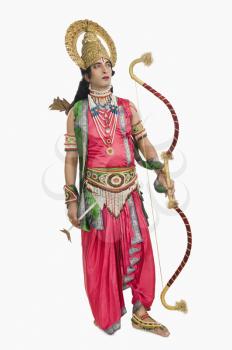 Man dressed-up as Rama and holding a bow and arrow