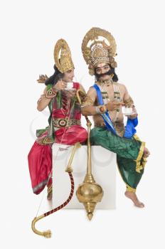 Two men dressed-up as Rama and Ravana and drinking tea