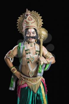 Portrait of a man dressed-up as Ravana and holding a mace