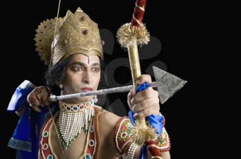Stage artist dressed-up as Rama and holding a bow and arrow