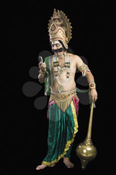 Man dressed-up as Ravana reading text message
