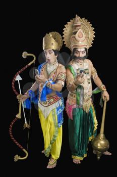 Two stage artists dressed-up as Rama and Ravana and reading text message