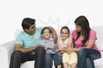 Close-up of a family sitting on a couch and smiling