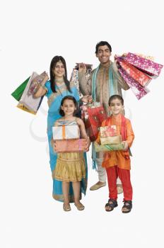 Family carrying shopping bags and gifts for Diwali