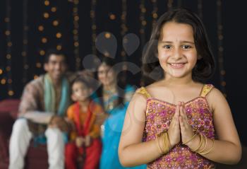 Girl greeting on Diwali festival with her family in the background