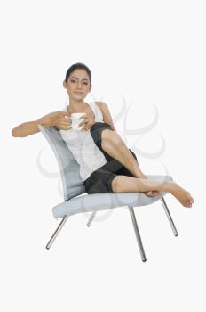 Woman sitting on a chair and drinking tea